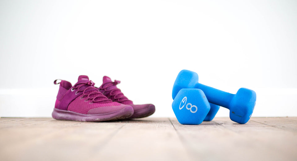 Laufschuhe und Hanteln auf Holzboden — Ratgeber zu Cannabis und Sport