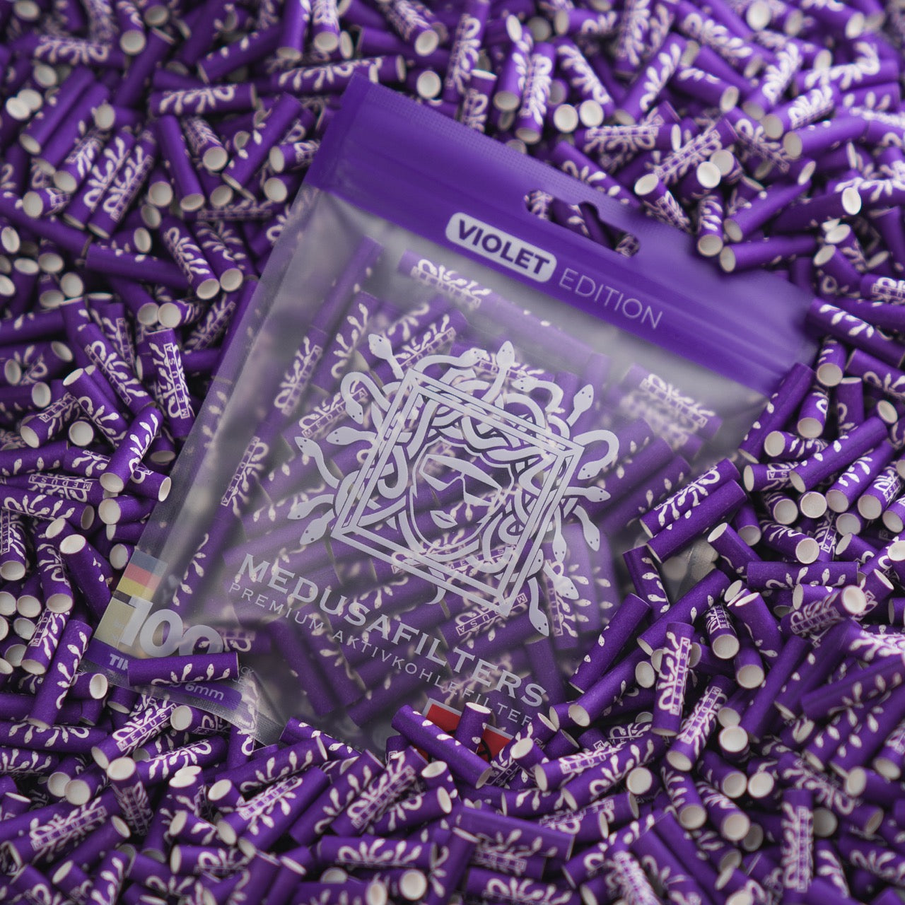 Medusafilters Premium Aktivkohlefilter mit Kokosnuss-Aktivkohle und veganen Fasercaps 100er Packung VIOLET Edition Tip Size 6 mm in Filter liegend 
