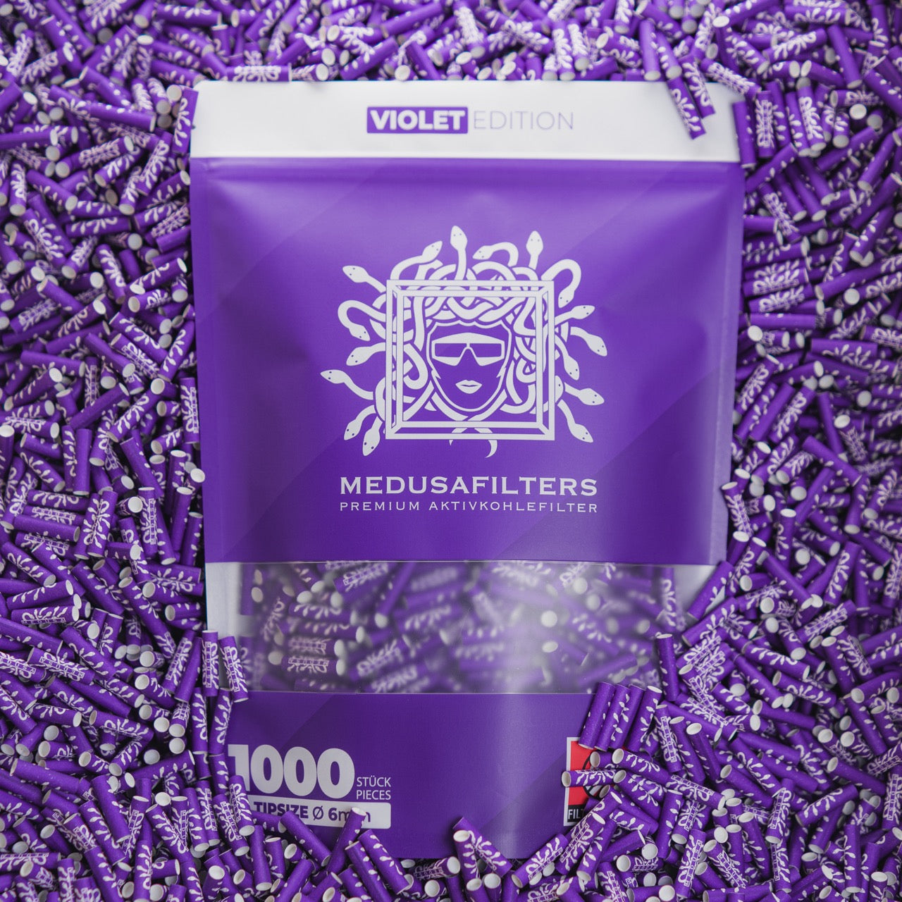 Medusafilters Premium Aktivkohlefilter mit Kokosnuss-Aktivkohle und veganen Fasercaps 1000er Packung VIOLET Edition Tip Size 6 mm in Filter liegend 
